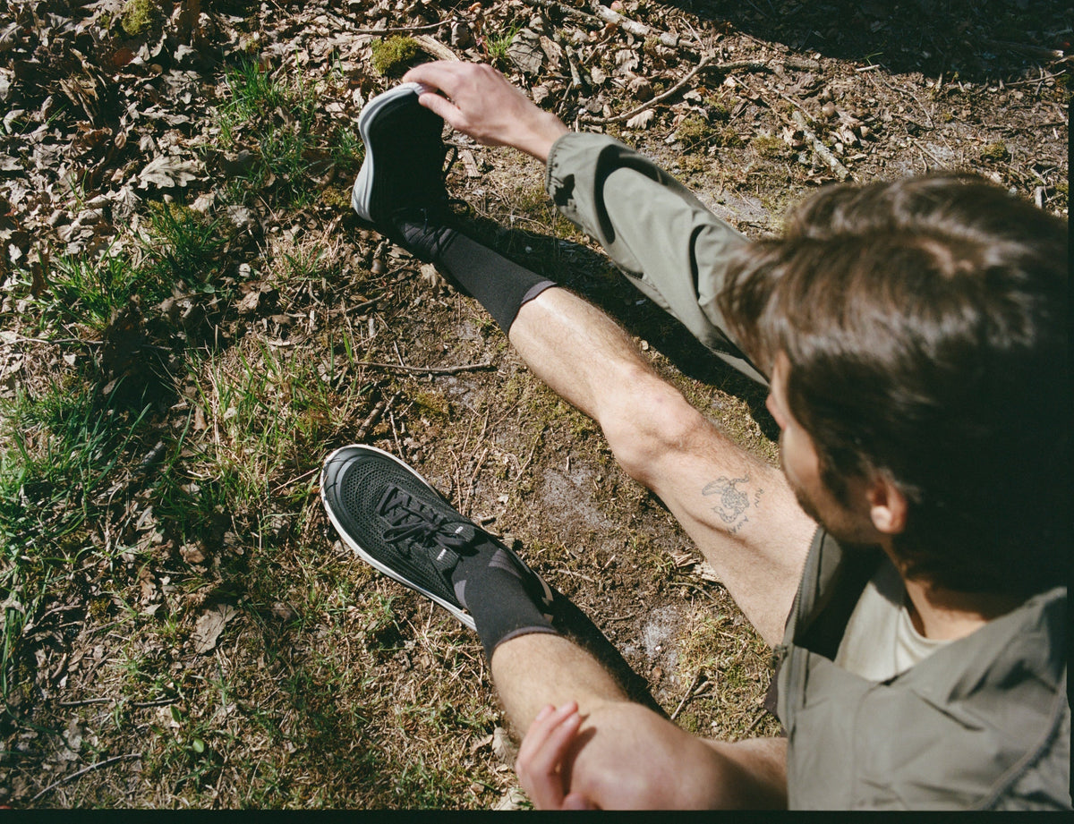 man stretching in shoes for active recovery